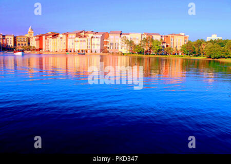 Italian city replica in Orlando, FL., USA: the blue water bathes the shores of a pleasant-seaview town, reflecting an amalgam of vivid painted colors. Stock Photo