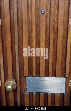 Letterbox and door furniture in old bank door Stock Photo