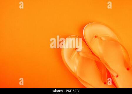 Stylish orange flip flop sandals, top view with copy space over yellow background Stock Photo