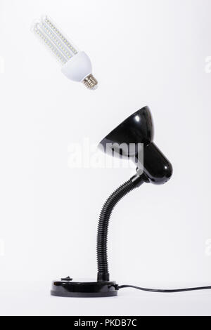 Led lamp in off position illuminated with black lamp holder. White background Stock Photo