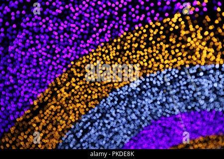 Purple and Gold Abstract Blurred of the Outdoors Illuminated Decorations against Dark Sky at Night Stock Photo