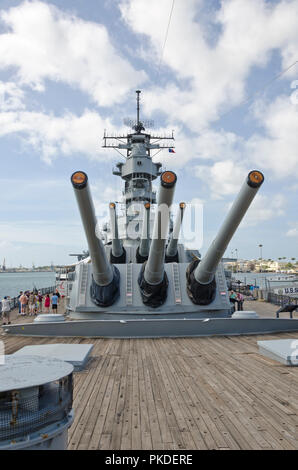 Tourists walk past gun turrets on USS Missouri (the ship on which the hostilities with Japan in WWII were officially ended) in Pearl Harbor, Hawaii. Stock Photo