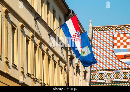 Flags of the Republic of Croatia and City of Zagreb on historic buildings on St Mark's Square in Zagreb, Croatia, roof of St Mark's church in backgrou Stock Photo