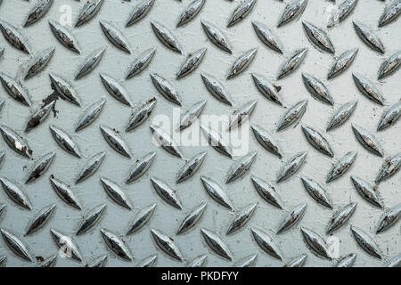 Close up of used rough steel sheet with diamond plate pattern/metallic texture background Stock Photo