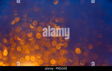 Blurred background with bokeh orange lights on dark blue background Stock Photo