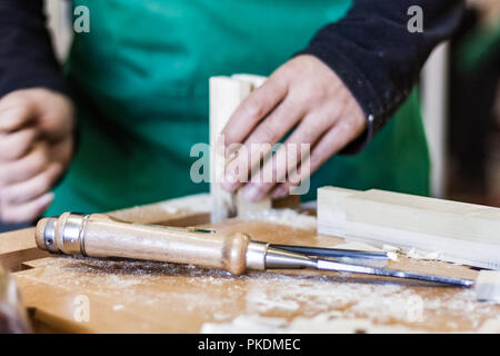 Professional woodshop store in Italy, focus on hands and working tools while cutting customized parts for bespoke oak furniture. Stock Photo