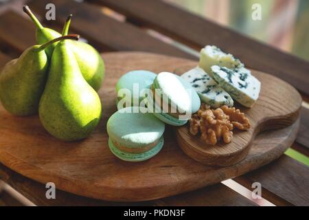 Macaroons, Crushed Walnuts And Dried Apricots On A Wooden Surface Stock Photo