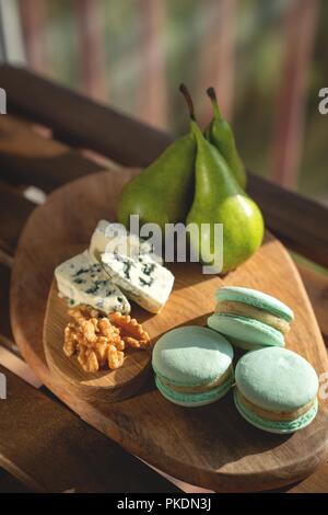 Macaroons, Crushed Walnuts And Dried Apricots On A Wooden Surface Stock Photo
