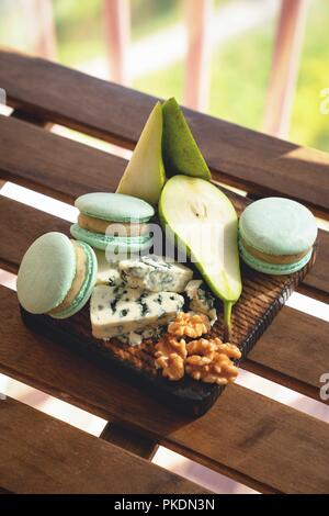 Macaroons, Crushed Walnuts And Dried Apricots On A Wooden Surface Stock Photo
