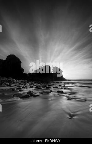 Sea Stacks and sunrays, Porthcotham Beach, Cornwall Stock Photo
