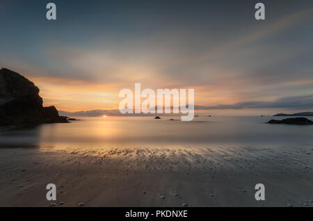 Setting Sun on serene tranquil shoreline, Porthcotham Beach, Cornwall Stock Photo