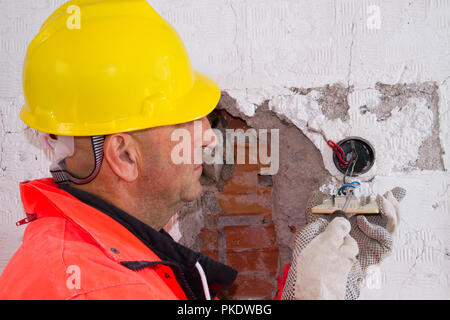 electrician at work with a plug Stock Photo