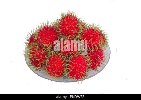 Thai popular fruit ,Red rambutan are edible in the serving dish. Stock Photo