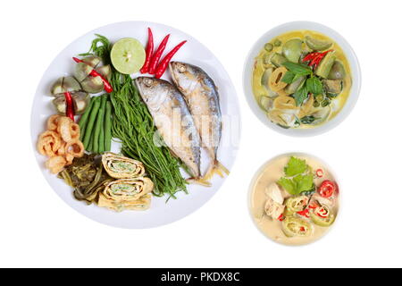 Coconut milk and fermented soy bean sauce and green curry with side dish as deep fired mackarels,omelet,crispy pork rind,halve green lemon,red chili a Stock Photo