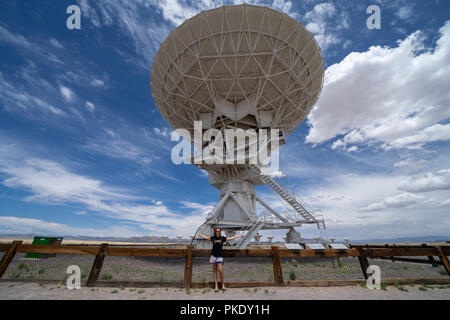 Beautiful woman poses to show scale of the Very Large Array located in New Mexico Stock Photo
