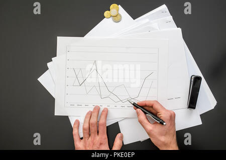 Top view of male hand holding a pen over a business document. Stock Photo