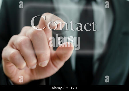 Detail of businessman hand pressing Contact us button on touch screen. Stock Photo