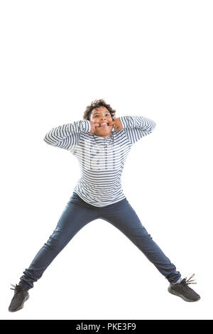 jomping grimacing boy. Cheerful young teenager boy jumping for joy. Isolated over white. Stock Photo