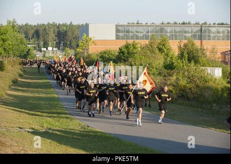 United States Army Garrison Bavaria displays its guidon during the 7th Army Training Command the 7th Army Training Command unit run July 25, 2018 at Grafenwoehr, Germany. This is the first team-building event since U.S. Army Europe restructured its mission command relationships this summer, as the 173rd Airborne Brigade, the 2nd Cavalry Regiment and the 12th Combat Aviation Brigade are realigned under the 7th Army Training Command.  The mission command restructuring is being conducted to improve the effectiveness and readiness of the U.S. Army's Europe-based combat brigades. Stock Photo