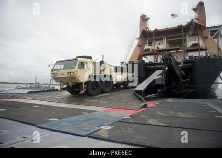 VIRGINIA BEACH, Va. An U.S. Army  Heavy Expanded Mobility Tactical Truck drives down the Military Sealift Command’s USNS Eugene A. Obregon’s (T-AK 3006) ramp onto the Roll On/ Roll Off Discharge Facility (RRDF) platform during the Trident Sun 18 exercise. Trident Sun 18 is a maritime prepositioning force (MPF) operation intended to provide training to reserve component personnel with regards to the in stream offload of military vehicles and equipment. Stock Photo