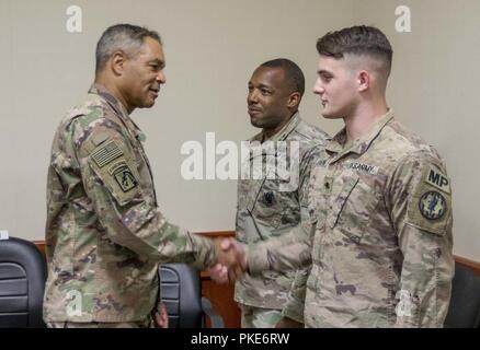 Lt. Gen. Michael X. Garrett, U.S. Army Central commanding general, congratulates Spc. Zachary Johnson, assigned to the 202nd Military Police Company at Camp As Saliyah, Qatar, July 26, 2018. Lt. Gen. Garrett presented Adkins with a coin for his efforts mentoring and assisting his peers, and for achieving a perfect score on the Army Physical Fitness Test. Stock Photo