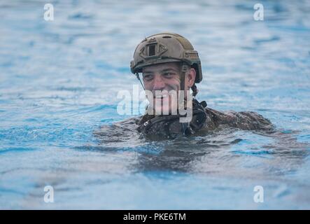 A Marine with the 31st Marine Expeditionary Unit’s Maritime Raid Force swims during a water confidence course at Camp Hansen, Okinawa, Japan, July 26, 2018. The FRP hosted the confidence course with 31st MEU Command Element Marines and Sailors in preparation for upcoming helocast training. The 31st MEU, the Marine Corps’ only continuously forward-deployed MEU, provides a flexible force ready to perform a wide-range of military operations. Stock Photo