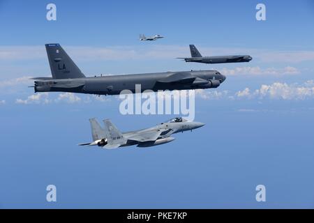 Two U.S. Air Force B-52H Stratofortress bombers and two Koku Jieitai (Japan Air Self-Defense Force) F-15 fighters execute a routine bilateral training mission in the vicinity of Japan, July 26, 2018. This mission was flown in support of U.S. Indo-Pacific Command’s Continuous Bomber Presence (CBP) operations, which are a key component to improving combined and joint service interoperability. Bilateral training missions such as this allow the two countries to improve upon combined capabilities, tactical skills, and relationships. Stock Photo