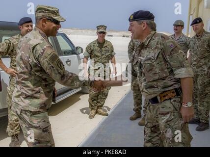 British Army Col. David Bennett greets U.S. Army Lt. Gen. Michael X. Garrett, U.S. Army Central commander, during a visit to the British Military Logistics Zone in Duqm, Oman, July 25, 2018. Lt. Gen. Garrett visited the logistics zone to assess the installation's ability to to support enduring USARCENT cooperation in the region. Stock Photo