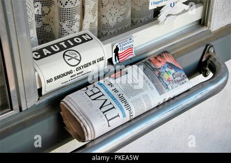 Daily Newspaper delivered to home of seniors for reading and news with oxygen  sign for breathing and support bar for walking on stairs California USA Stock Photo