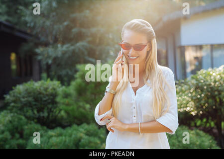 Positive joyful woman having a phone conversation Stock Photo