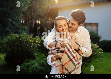 Joyful positive woman standing in front of her boyfriend Stock Photo
