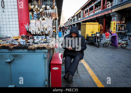 A vendor selling calligraphy sets at the Panjiayuan Antique Market; Beijing, China Stock Photo