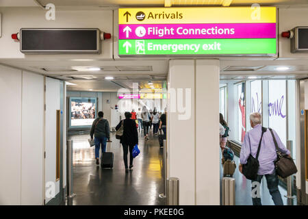 London England,United Kingdom,Great Britain,Heathrow Airport LHR,directions,sign,flight arrivals,connections,emergency exit,adult adults man men male, Stock Photo