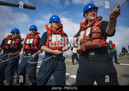 Sailors handle a line aboard the San Antonio-class amphibious transport ...