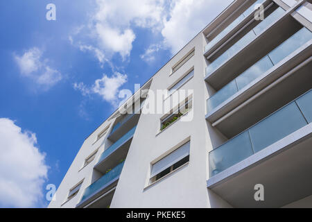 Modern new apartment with concrete exterior walls and large glass balconies in Italy. Bottom view. Stock Photo