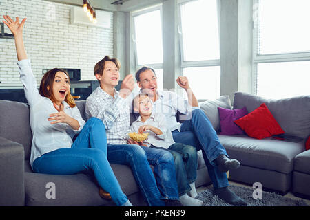 Happy family having fun watching TV sitting. Stock Photo