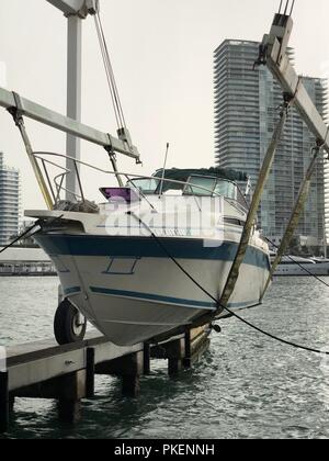 A 28-foot pleasure craft that was used in a suspected illegal migrant smuggling operation is cradled in Miami, July 30, 2018. The boat was interdicted by the crew of the Coast Guard Cutter Bernard C. Webber embarked two suspected smugglers and three migrants and transferred custody of them to U.S. Boarder Patrol and Homeland Security Investigations. Stock Photo