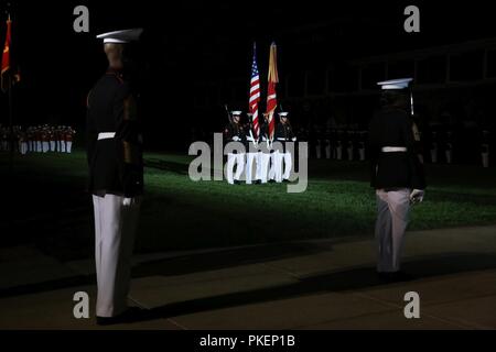 Marines with U.S. Marine Corps Color Guard march across the parade deck during the Staff Non-Commissioned Officer Friday Evening Parade at Marine Barracks Washington D.C., July 27, 2018. The guest of honor for the parade was Dan Smith, acting director, National Park Service, and the hosting official was Sgt. Maj. Ronald L. Green, Sergeant Major of the Marine Corps. During the SNCO Friday Evening Parade, SNCO’s assume the billets of key leaders’ marching positions normally filled by officers and non-commissioned officers. Stock Photo