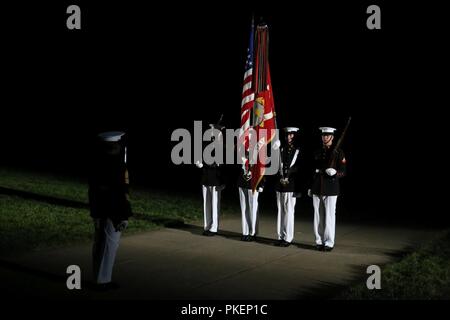 Marines with the U.S. Marine Color Guard present the National Ensign during the Staff Non-Commissioned Officer Friday Evening Parade at Marine Barracks Washington D.C., July 27, 2018. The guest of honor for the parade was Dan Smith, acting director, National Park Service, and the hosting official was Sgt. Maj. Ronald L. Green, Sergeant Major of the Marine Corps. During the SNCO Friday Evening Parade, SNCO’s assume the billets of key leaders’ marching positions normally filled by officers and non-commissioned officers. Stock Photo