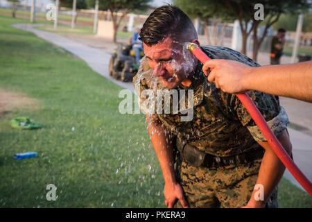 U.S. Marines assigned temporary additional duty to Provost Marshal’s Office, Marine Corps Air Station Yuma, participate in Oleoresin Capsaicin (OC) spray as part of a Security Augmentation Force (SAF) qualification event on MCAS Yuma, AZ, July 31, 2018. The SAF Marines are required to receive level one OC contamination in order to know how to properly function and provide security while being affected by the spray. Stock Photo
