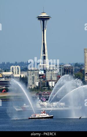 The crew of the Coast Guard Cutter Mellon, a 378-foot High Endurance Cutter home-ported in Seattle, sails past the Seattle Fire Department Boat Leschi and the Seattle Space Needle during the annual Parade of Ships in Seattle, July 31, 2018.    The Parade of Ships is part of the annual Seattle Seafair air and sea events held each summer in the Seattle area.    U.S. Coast Guard Stock Photo