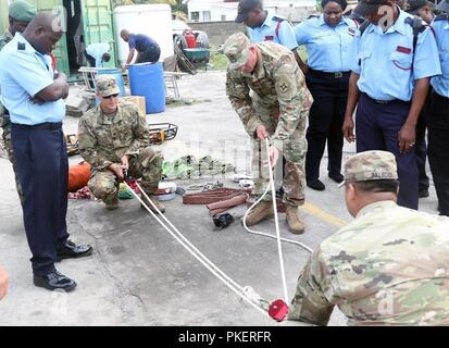 (From left to right) Sgt. Andrew D. Ware, Sgt. 1st Class Robby E. Creech and Staff Sgt. Jose J. Palacios, with the Florida National Guard’s C-ERFP, demonstrate a rope rescue 2:1 pulley system operation for the St. Kitts and Nevis fire department. The four-person team is supporting the State Partnership Program by training local emergency response agencies on search and extraction operations in St. Kitts and Nevis, July, 26 2018. Stock Photo