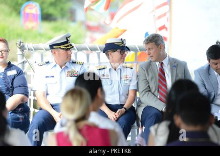 U.S. Rep. Bill Huizenga, Michigan, speaks to Rear Adm. Joanna Nunan, Ninth District Commander, during a naturalization ceremony aboard Coast Guard Cutter Escanaba in Grand Haven, Michigan, August 1, 2018. The ceremony took place on the flight deck of the Escanaba and naturalized 18 legal immigrants. Stock Photo
