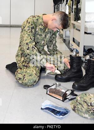 LAKES, Ill. (July 26, 2018) Naval ROTC midshipman candidate Luke Lalumandier, an incoming freshman at the University of Illinois from St. Louis, polishes his boots in preparation for a personnel inspection in the USS Triton Recruit Barracks at Recruit Training Command (RTC). More than 65 young men and women entering their freshman year of the NROTC program participated in a two-week pilot program designed to provide standardized entry-level militarization and prepare midshipmen with a common training orientation. The indoctrination serves as a standard training launch point for the future nava Stock Photo