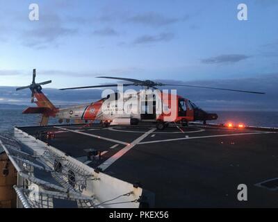 A Coast Guard Air Station MH-60 Jayhawk aircrew prepares to take off from the Coast Guard Cutter Healy (WAGB-20) near Kodiak Island, Alaska, July 31, 2018. The helicopter crew conducted deck landing qualification training that allows aircrews to be deployed with the cutter. U.S. Coast Guard photo. Stock Photo