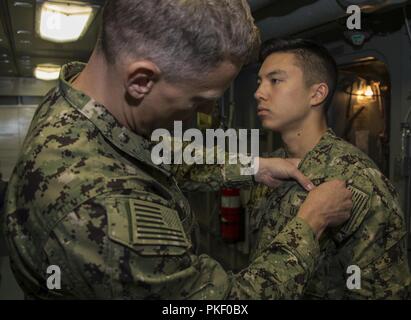 NEWPORT NEWS, Va. (Aug. 3, 2018) Cryptologic Technician (Collection) 2nd Class Benjamin Mizuo, from Everett, Washington, assigned to USS Gerald R. Ford (CVN 78), receives his Enlisted Information Warfare Specialist pin from Senior Chief Intelligence Specialist Michael Linares.