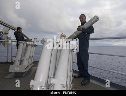 ATLANTIC OCEAN (July 30, 2018) Cryptologic Technician (Technical) 3rd Class Jarrell Gladden, from Baltimore, left, and Cryptologic Technician (Technical) Seaman Allen Pinder, from Columbus, Ohio, remove chaff rounds from the starboard mark 36 decoy launching system aboard the Wasp-class amphibious assault ship USS Iwo Jima (LHD 7), July 30. Iwo Jima is deployed with its amphibious ready group in support of maritime security operations and theater security cooperation efforts in Europe and Middle East. Stock Photo