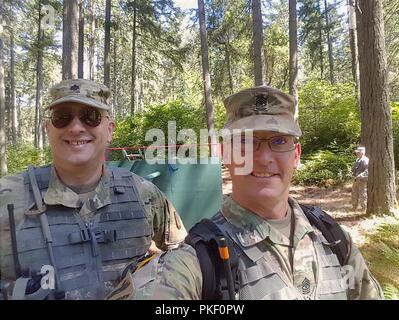 The Command Sgt. Maj. of OCS Phase III, Washington Army National Guard, Sgt. Maj. Travis E. Wise takes a selfie with Lt. Col. William B. Pola, the Commander of 2nd Battalion, 205th Regiment during consolidated OCS Phase III on Joint Base Lewis-McChord, July 31, 2018. Stock Photo