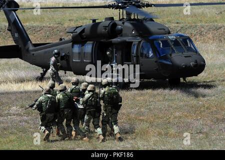 A U.S. Georgia Army National Guard UH-60 Black Hawk helicopter crew loads Georgian Special Operations Forces  during a combined urban operation exercise with U.S. Soldiers, Ukrainian and German forces as part of Noble Partner at Vaziani Training Area, Georgia, Aug. 5, 2018.  Noble Partner 2018 is a Georgian Armed Forces and U.S. Army Europe cooperatively-led event improving readiness and interoperability of Georgia, U.S. and participating nations. Stock Photo