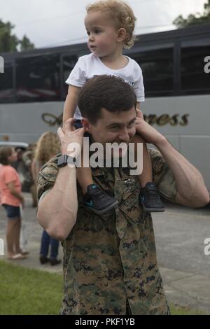 A Navy corpsman with the 26th Marine Expeditionary Unit carries his son on his shoulders at Camp Lejeune, N.C. Aug 5, 2018. Marines with the 26th MEU returned home from a six-month deployment at sea to the U.S. Central, Africa and European Command areas of operations. Stock Photo